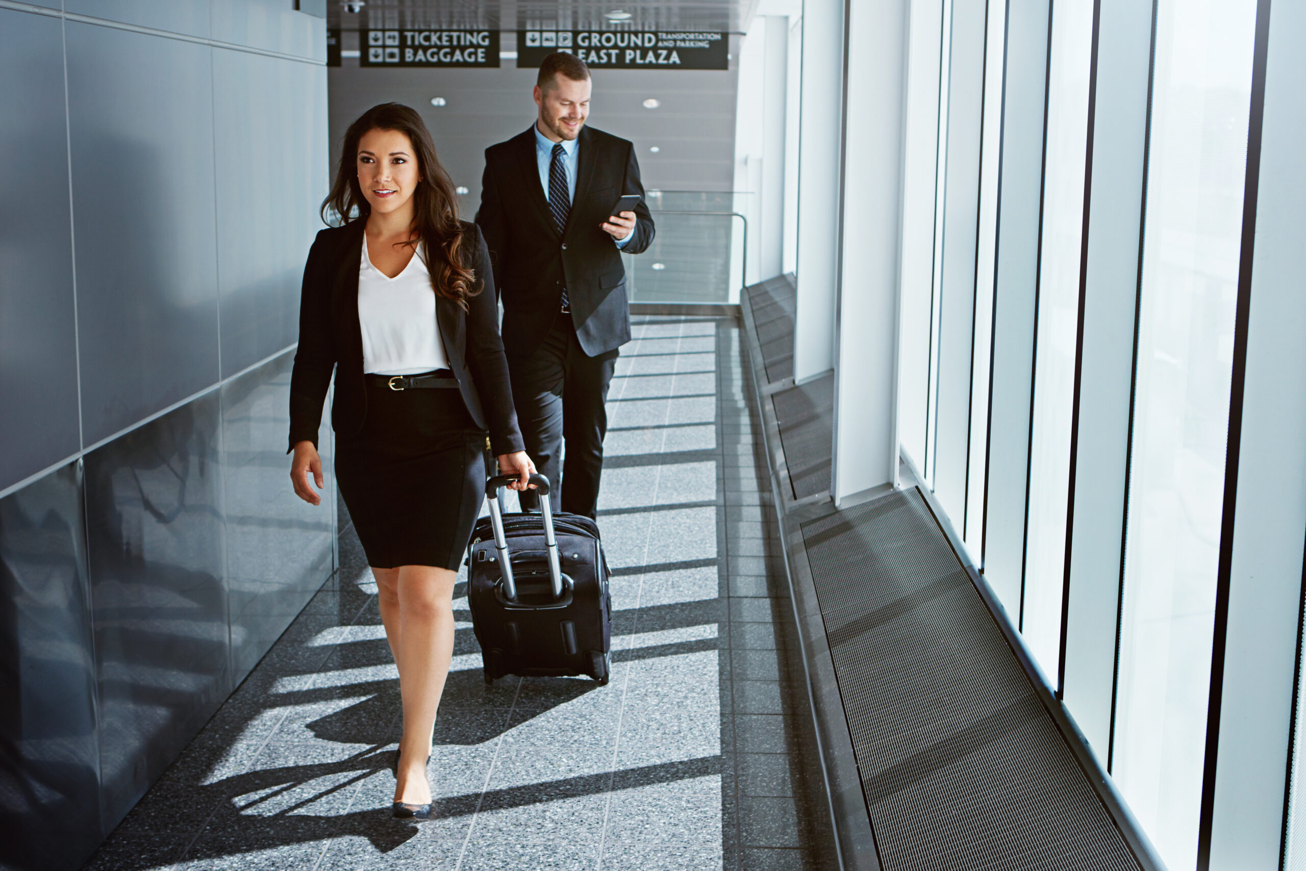 Shot of two executive businesspeople walking through an airport during a business trip